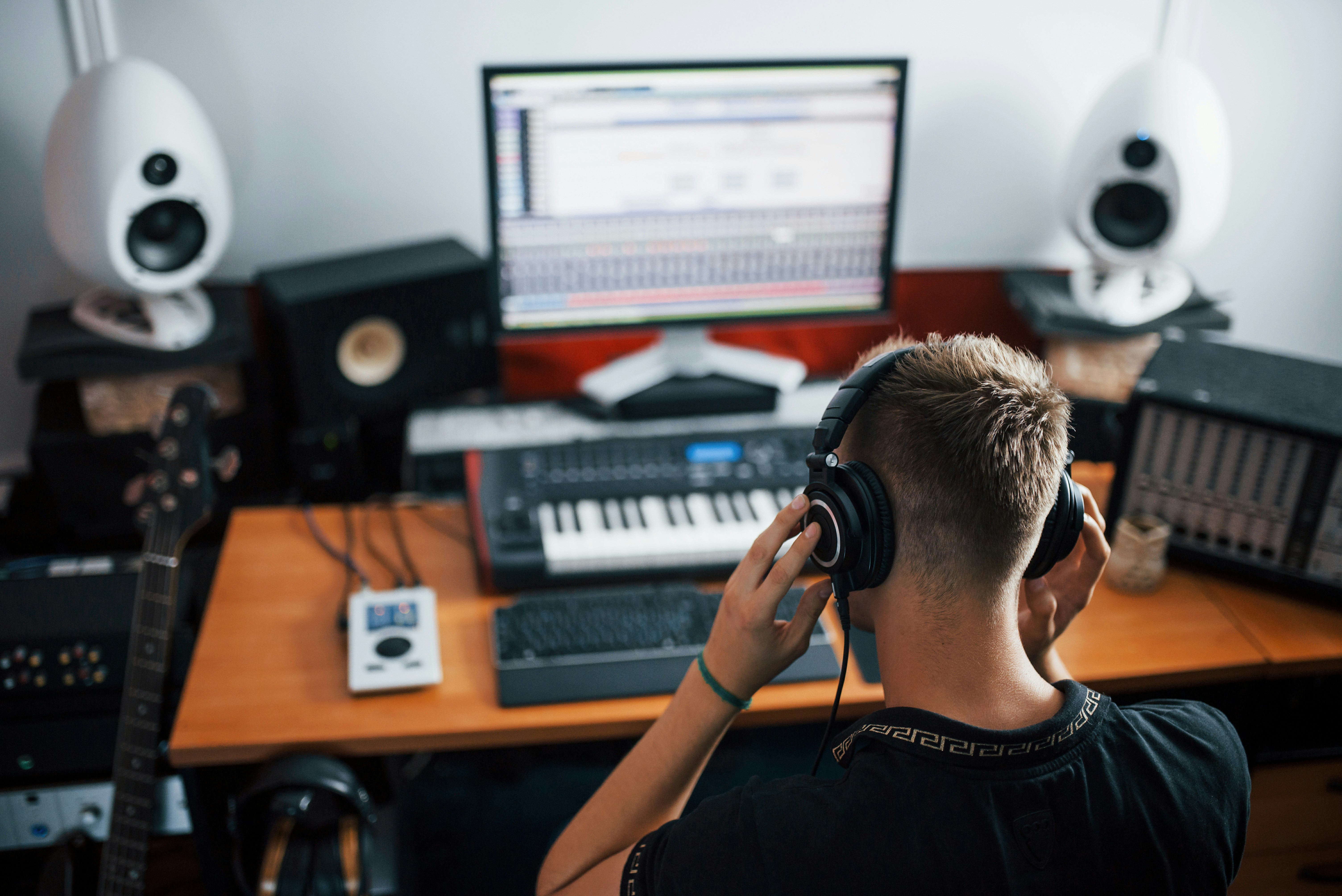 music artist at laptop keyboard listening to headphones
